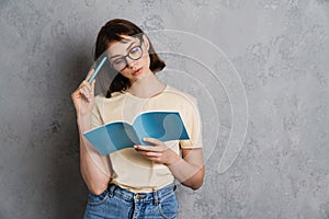 Beautiful pensive young woman reading a book