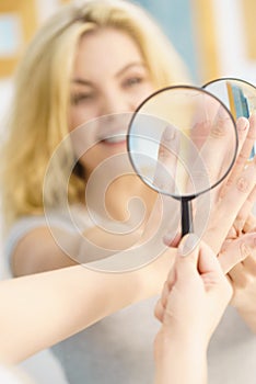 Woman using magnifer on nails