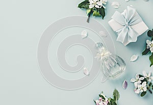 Beautiful perfume bottles and spring flowers on blue background