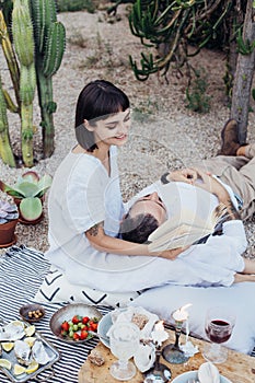 Couple on romantic date lay on picnic blanket