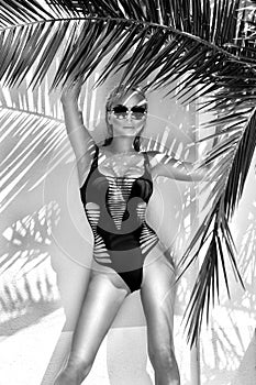 Beautiful phenomenal stunning elegant blonde model woman with perfect face wearing a sunglasses stands with elegant erotic sw