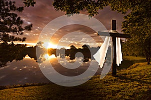 Beautiful photo illustration of an Easter morning sunrise on a cross by a calm lake