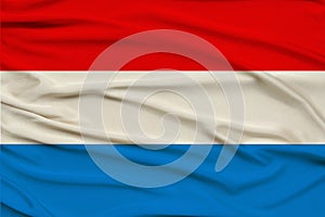 Beautiful photo of the Luxembourg national flag on delicate shiny silk with soft draperies, the concept of state power, country