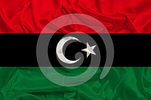 Beautiful photo of the national flag of Libya on delicate shiny silk with soft draperies, the concept of state power, country life
