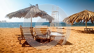 Beautiful photo of old wooden sun beds or loungers on the empty beach at sunny windy day