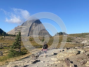 A beautiful photo of a woman hiking the landscape of Hidden Lake trail in Glacier National Park