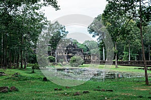 A beautiful photograph of one of the courtyards of the ruins of Ankgor Thom in Cambodia surrounded by a beautiful green forest