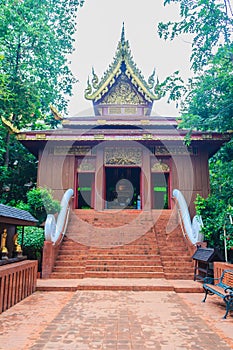 Beautiful Phra Uposatha or Ubosoth in Chiang Saen style with nicely carved wooden structure with unique carved doors at Wat Phra