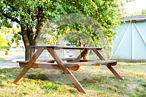 Beautiful picnic area with wooden table in sunny autumn garden. Resting place on park. Picknick place in summer Orchard. Wooden pi