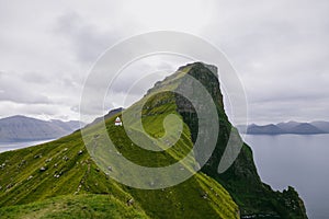 Beautiful picture of green mountains and Kalsoy Lighthouse in Faroe Islands