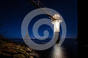 Beautiful picture of a lighthouse at night under the starry sky