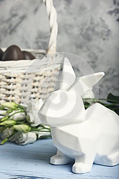 A beautiful picture with a white Easter Bunny. Basket with chocolate eggs. Holy holiday