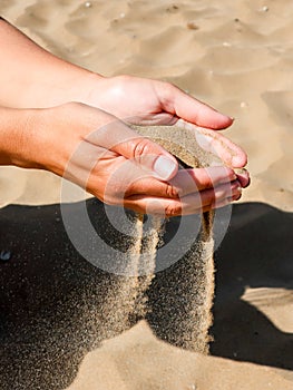 Beautiful picture of a woman`s hands holding and pouring sand