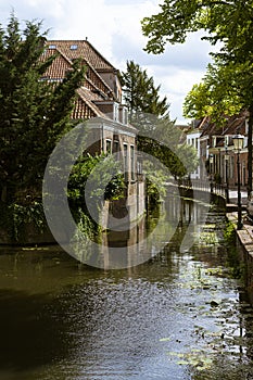 Beautiful and picturesque landscape of the village of Amersfoort.  Typical dutch houses in front of a canal, riverside with trees