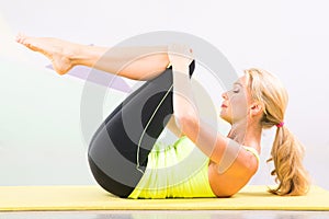 Beautiful pilates instructor with yellow yoga mat