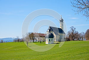 Beautiful pilgrimage chapel Veitskapelle Wilparting, landscape and St. Marinus church Irschenberg, view to bavarian alps