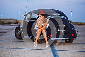 Beautiful pin-up girl posing with hot road car