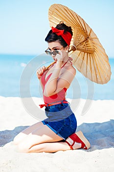 Beautiful pin-up with umbrella at sea