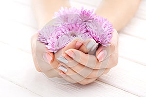 Pinc manicure with chrysanthemum flowers. spa