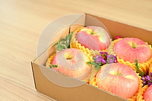 beautiful pink apple in the box on wood floor, healthy fruit