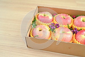 beautiful pink apple in the box on wood floor, healthy fruit