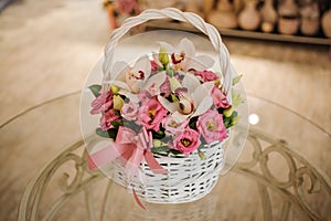 Beautiful pink bouquet of mixed flowers in basket on table