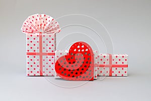 Beautiful pink boxes for gifts, a red wooden heart on a gray background. Red box, Holiday concept, Valentine`s Day, wedding,