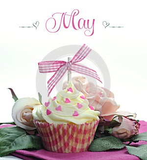 Beautiful pink heart or Mothers Day theme cupcake with seasonal flowers and decorations for the month of May