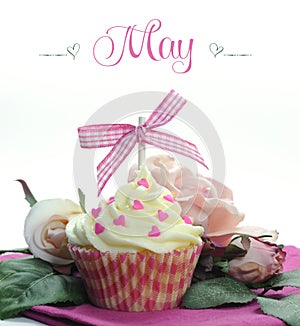 Beautiful pink heart or Mothers Day theme cupcake with seasonal flowers and decorations for the month of May photo