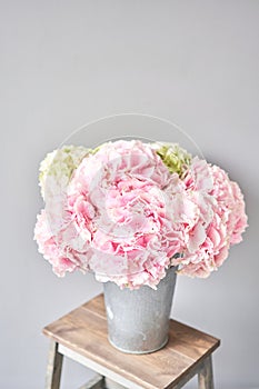 Beautiful pink hydrangea flowers in a vase on a table . Bouquet of light pink flower. Decoration of home. Wallpaper and