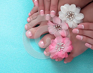 Beautiful pink manicure and pedicure with flowers photo