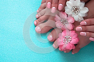 Beautiful pink manicure and pedicure with flowers photo