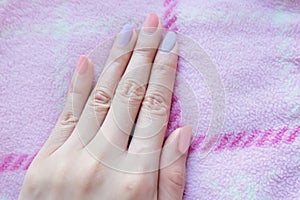 Beautiful Pink Nail Polish. Female Hands with Pink Nails Manicure on Pink Fabric Background