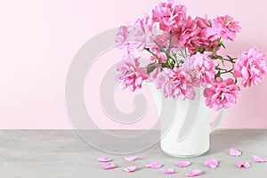 Beautiful pink rose flowers bouquet in white vase on gray table