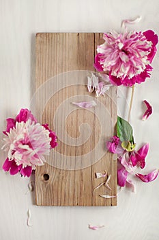 Beautiful pink, rose peonies on wood plate