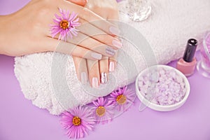 Beautiful pink and silver manicure with flowers and spa essentials