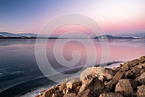 A beautiful pink sky in the morning during sunrise on a frozen lake. Winter landscape in bright colors.Dam Liptovska Mara,