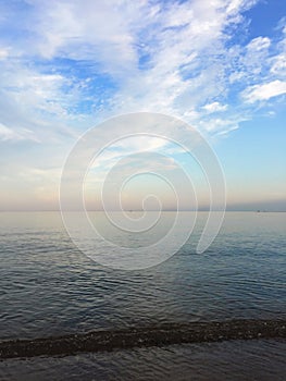 Beautiful pink sunset over the sea with blue sky and white clouds