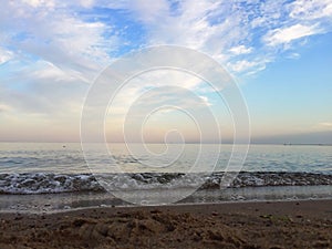 Beautiful pink sunset over the sea with blue sky and white clouds