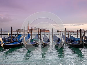 Beautiful and pink sunset from San Marco square, Venice, Italy, and the gondolas in the foreground