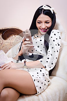 Beautiful pinup woman looking happy smiling with mobile phone