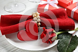 Beautiful place setting with decorative heart on white wooden table, closeup view. Valentine`s day romantic dinner