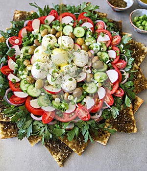 Beautiful plate display of homemade Labane cheese balls with Olive oil, za`atar pita bread toast and fresh vegetabl