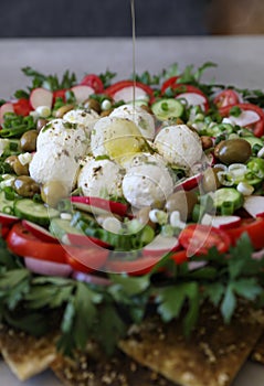 Beautiful plate display of homemade Labane cheese balls with Olive oil, za`atar pita bread toast and fresh vegetabl