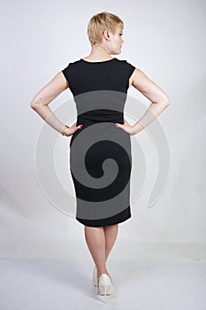 Beautiful plus size blonde girl with short hair in a fashionable office dress on a white background in the Studio. stylish young w