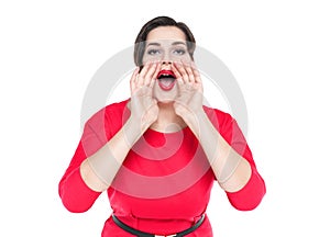 Beautiful plus size woman shouting through megaphone shaped hand