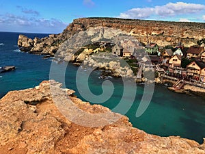 Beautiful popeye village on the island of malta, with colorful houses and a crystal blue sea that enchant photo