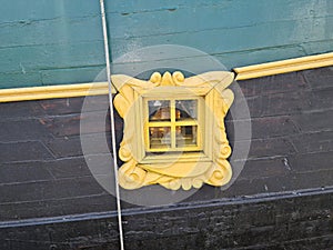 Beautiful porthole window in the wooden board of an old sailing ship
