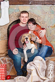 Beautiful portrain of young family with cute beagle dog on the New Year eve