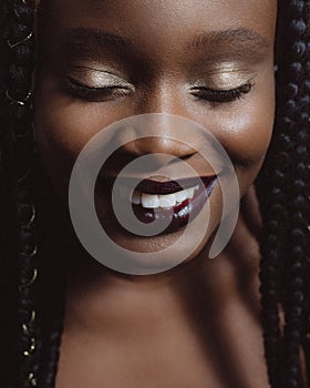 Beautiful portrait of an african american woman with fashionable makeup with eyes closed and smile